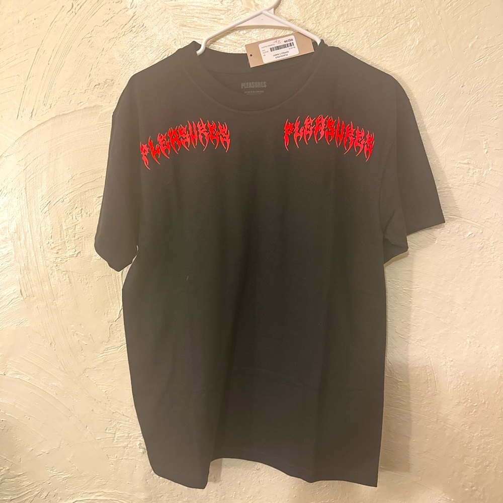 black Pleasures graohic tee with “pleasures” written on front and back